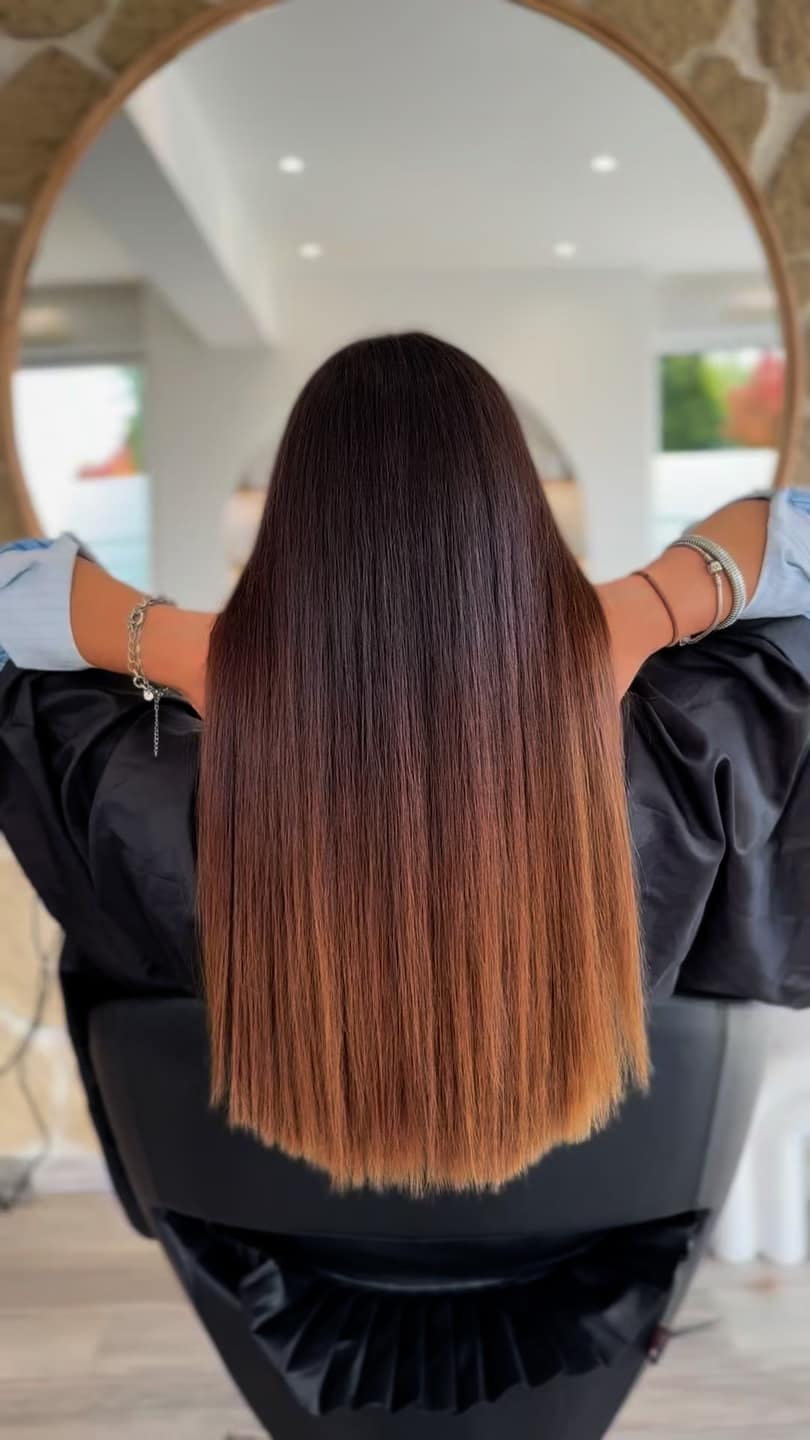Coiffure brune longue lissée, reflet sur miroir du salon